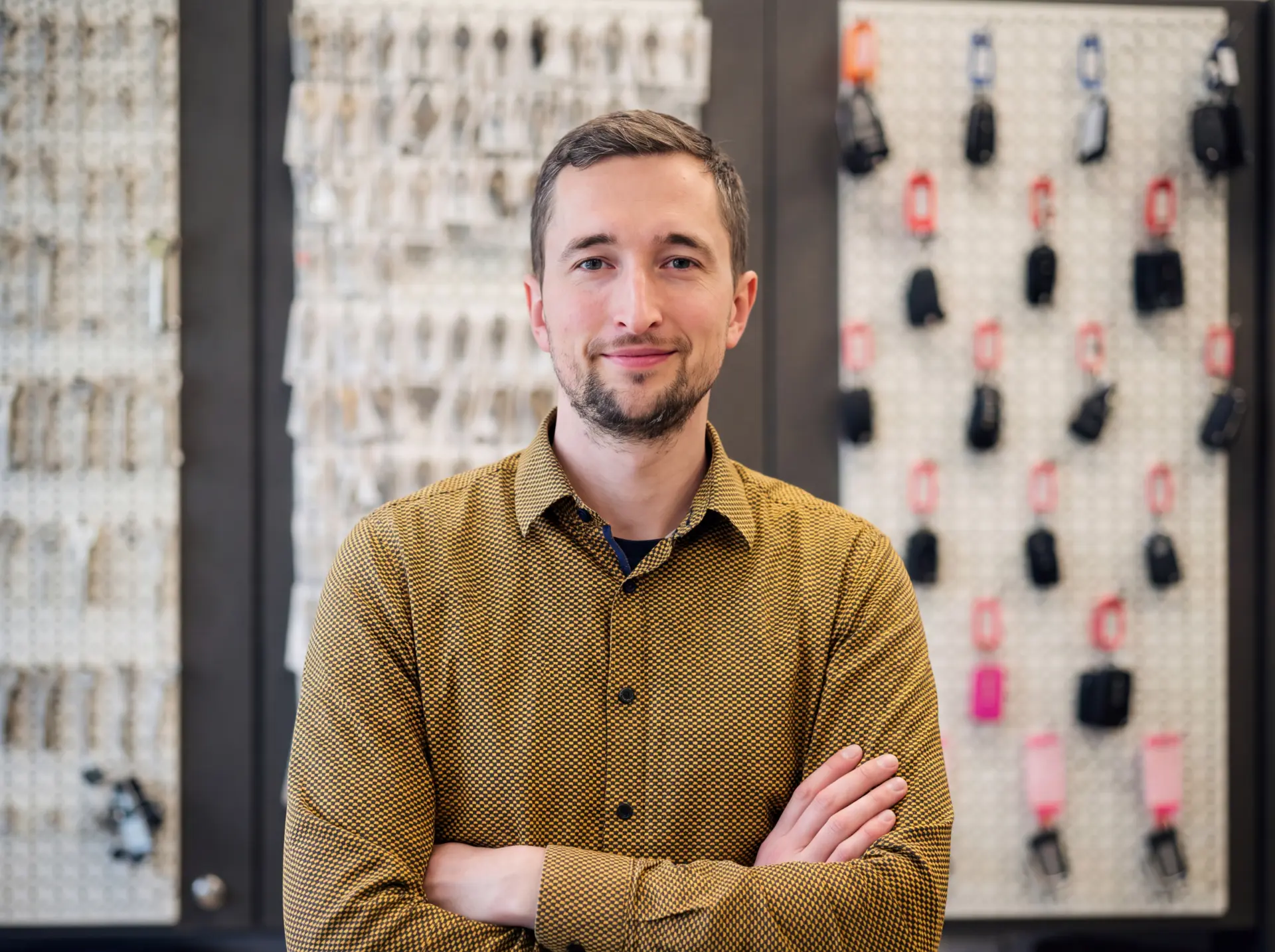 Owner of Schuh- und Schlüsselkönig in front of the key wall in the shop in Elmshorn
